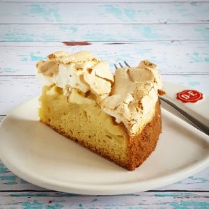 Een puntje meringue appeltaart op een gebaksbordje.