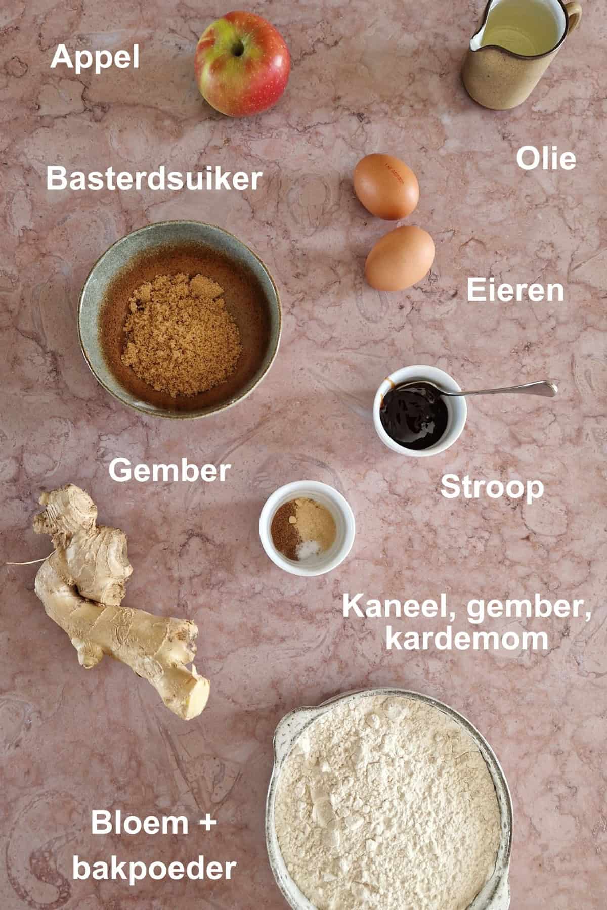 De ingrediënten om appelcake te maken, uitgestald in kommetjes.