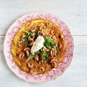 Frittata met prei en garnalen op een ouderwets bord.