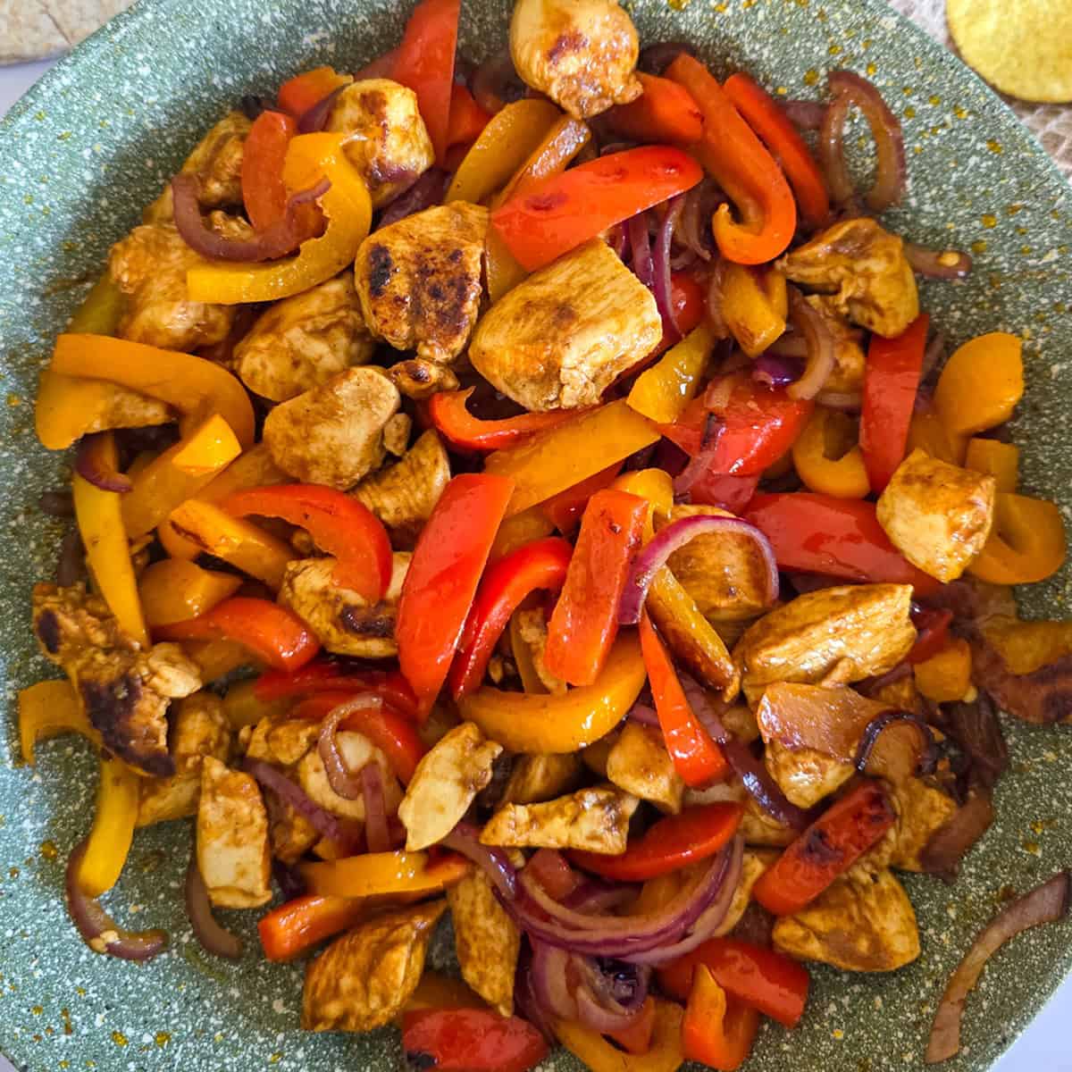 Een close-up van een pan met kip fajita met paprika.