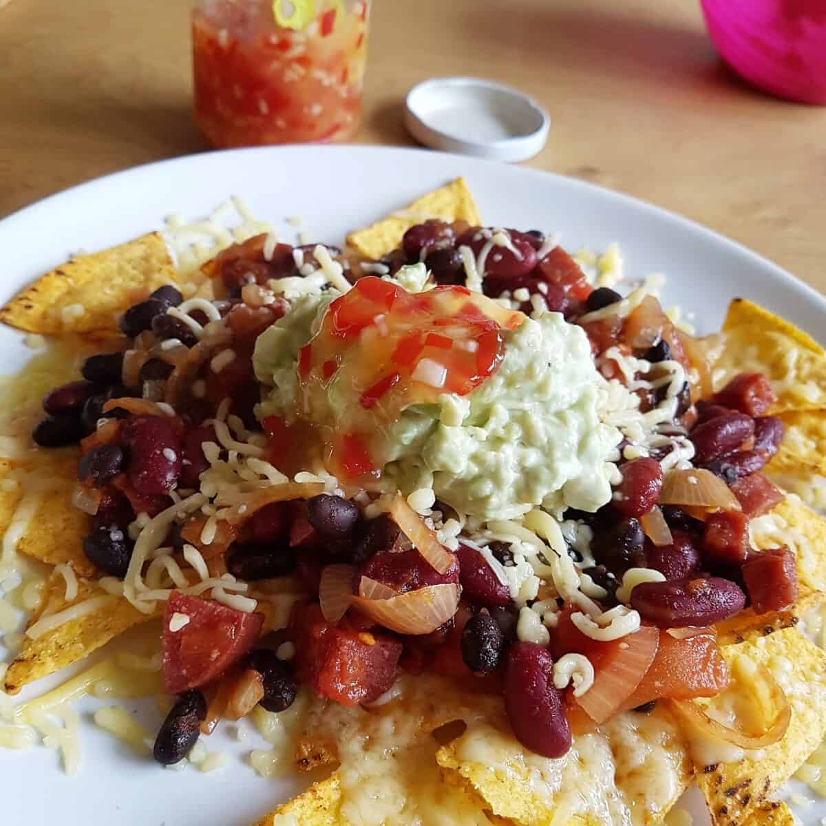 Zoete chilisaus zelf maken is heel makkelijk, erg lekker op een stapel nachos zoals op deze foto.