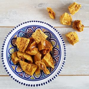 Een grote schaal met stukken honeycomb, snoep gemaakt van suiker in de vorm van een honingraat.
