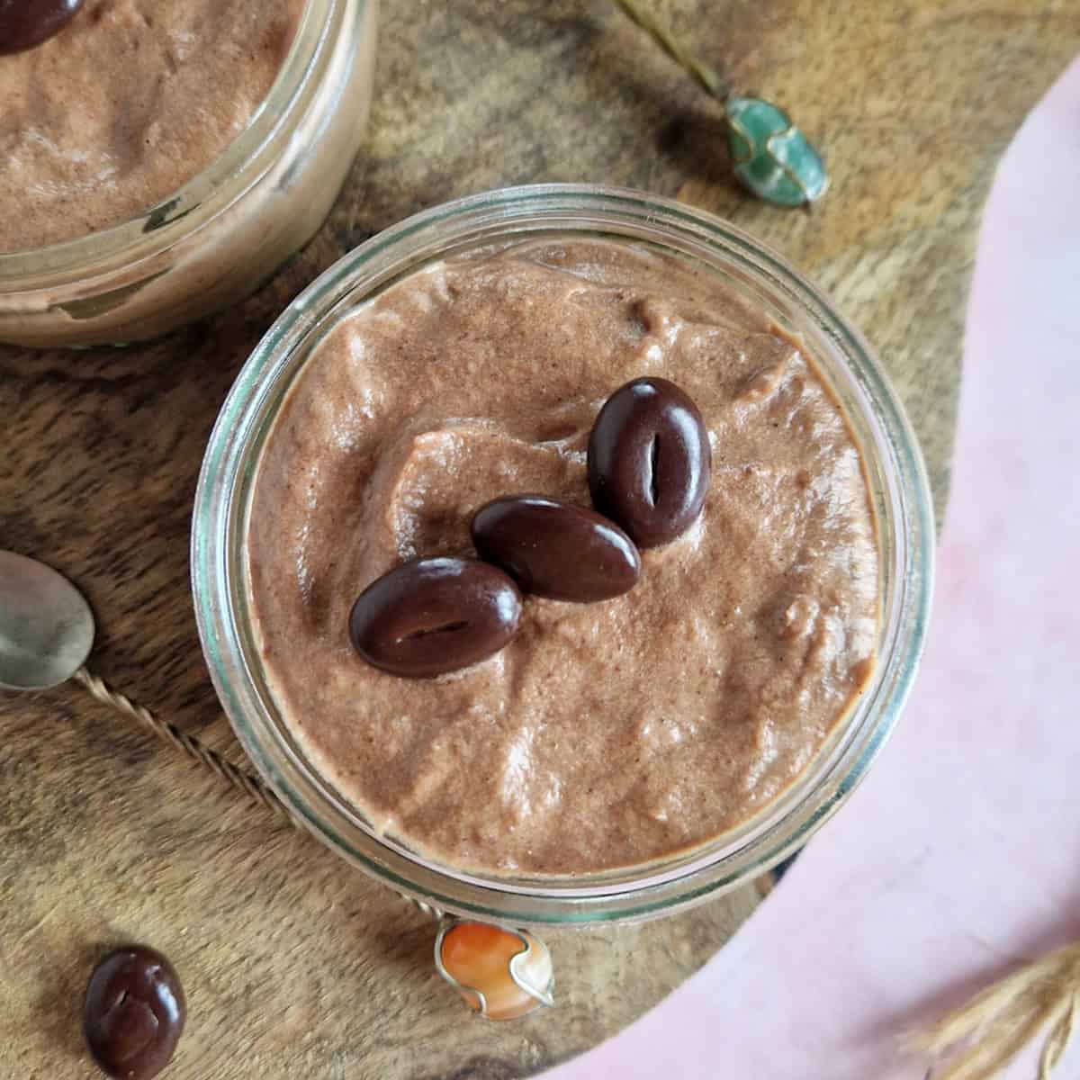 Chocolade kastanjemousse in een glazen potje. De kastanje mousse is gegarneerd met koffieboontjes.