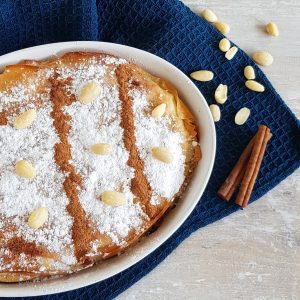 Pastilla - of bestilla - een Marokkaanse pastei met kip, bestrooid met veel poedersuiker en kaneel, met amandelen ter garnering.