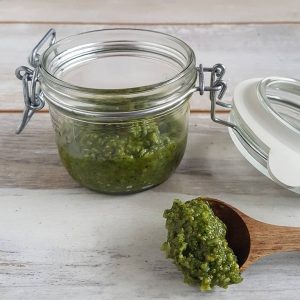 Zelf pesto maken, een potje zelfgemaakte pesto met een lepeltje van de pesto ernaast.