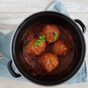 Ouderwetse gehaktballen in een braadpan met een dikke jus van tomaten en ketjap.