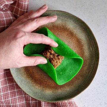 Stap 2 in een fotoreeks om te laten zien hoe je de dadar gulung kunt vouwen.