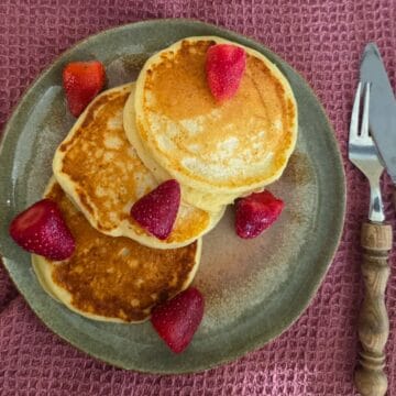 Cottage Cheese pannenkoeken met vers fruit, op een groen bord.
