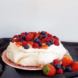 Pavlova met rood fruit en opgeklopte slagroom.
