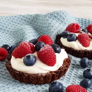 Havermouttaartjes met mascarpone en fruit, op een blauwe doek.