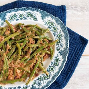 Sajoer boontjes op een ouderwets bord, de Indonesische boontjes zijn voorzien van een laag smakelijke boemboe.