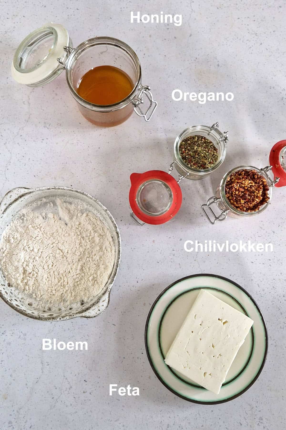 Ingredienten gebakken feta: feta, bloem, honing, oregano en chilivlokken.
