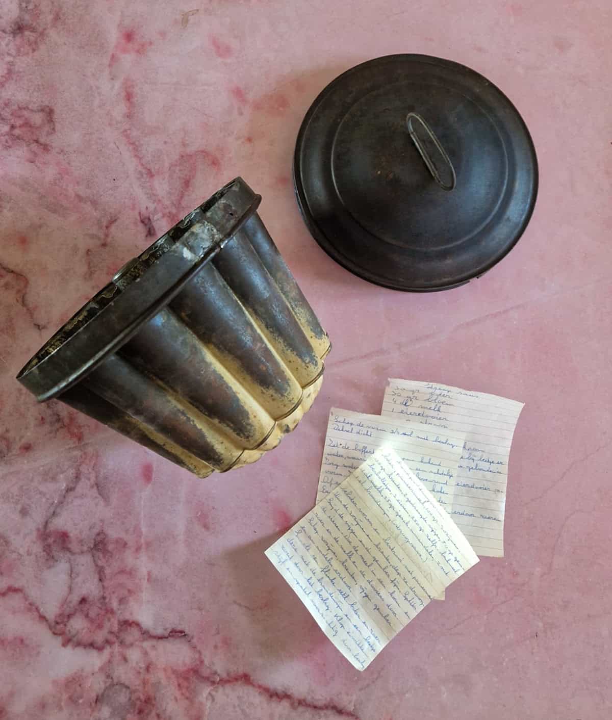 Een ouderwetse ketelkoekvorm die ik gebruik om broeder in de pan te maken. Ernaast briefjes met een handgeschreven recept voor broeder.