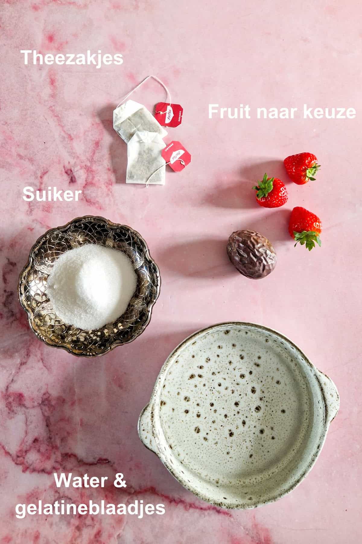 De ingrediënten voor dit makkelijke dessert: water met gelatine, theezakjes, suiker en vers fruit.