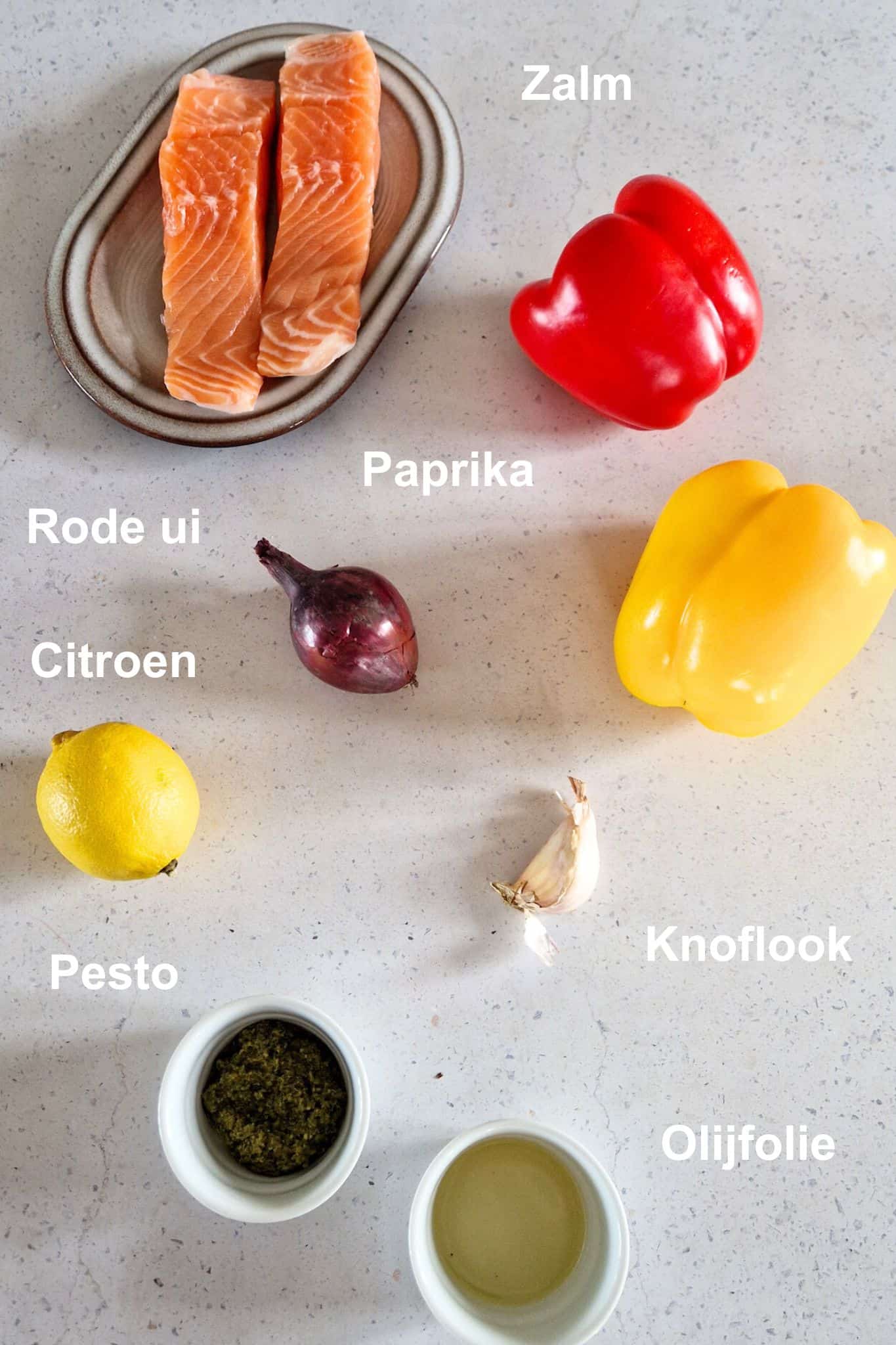 De ingrediënten voor een zalm traybake recept bij elkaar uitgestald.