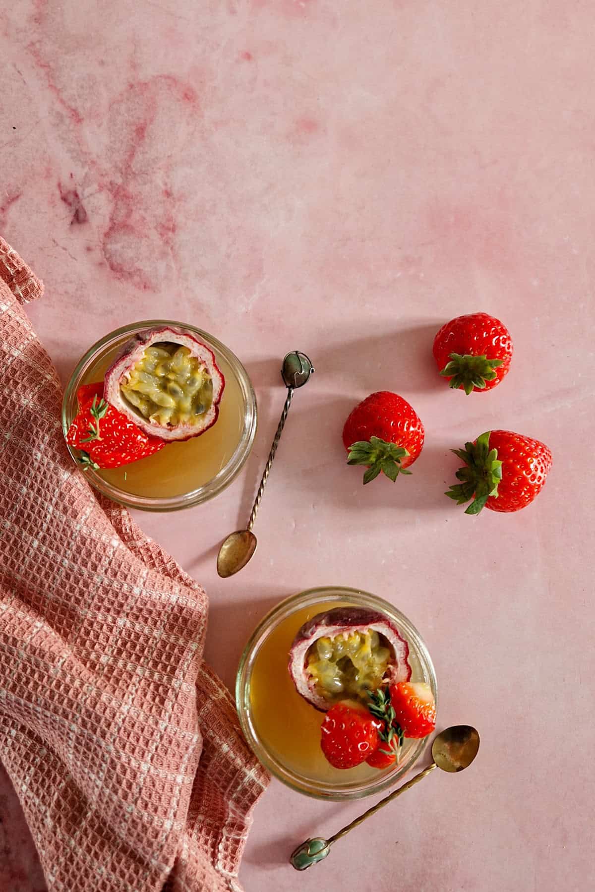 Jelly toetje met vers fruit - twee bakjes met jelly, gegarneerd met passievrucht en aardbeien.