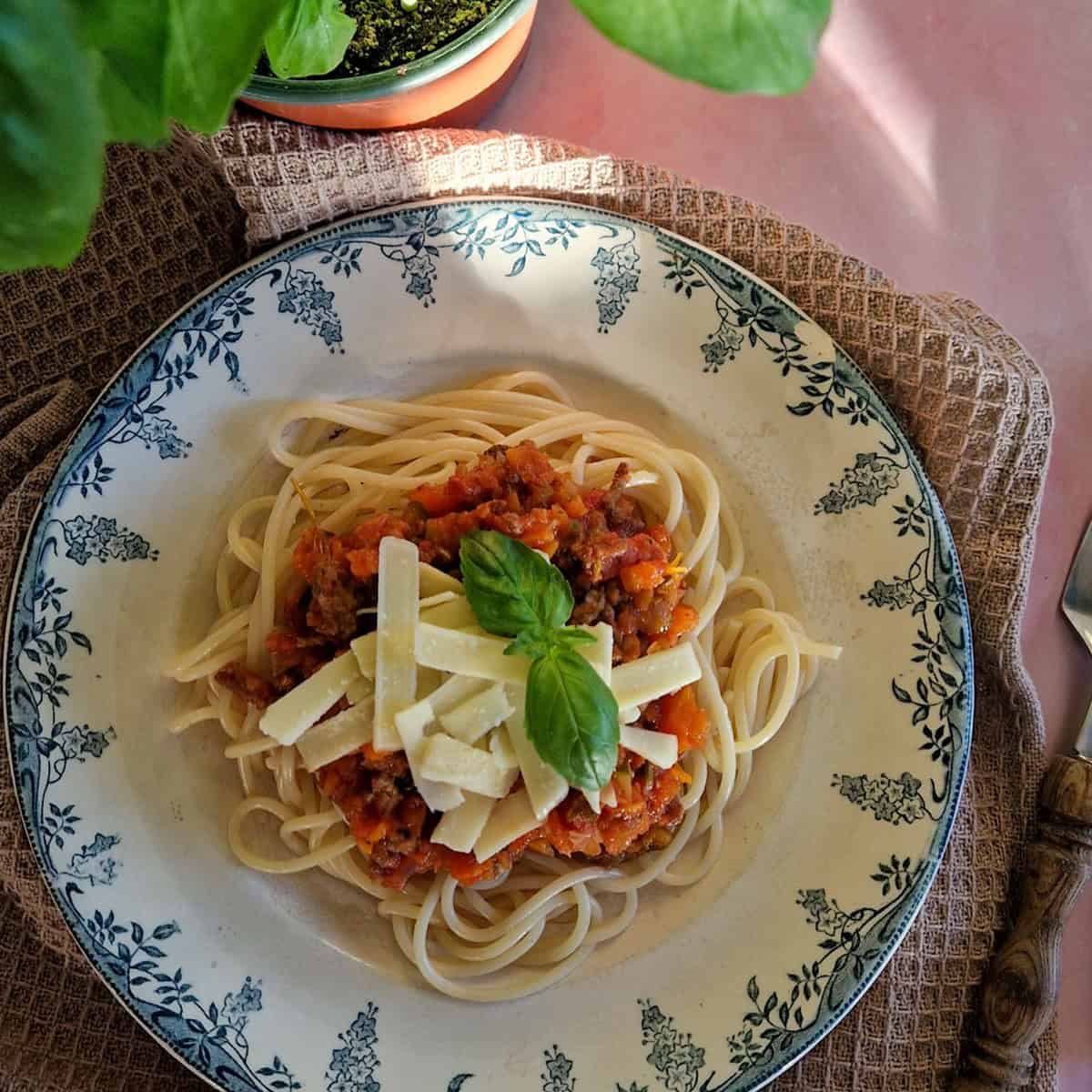 Pasta Bolognese, een bord pasta met gehaktsaus, gegarneerd met parmezaanse kaas.