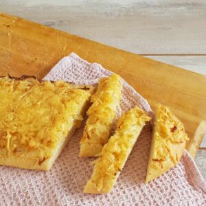 Stukken uienkruier met kaas op een houten serveerplank.