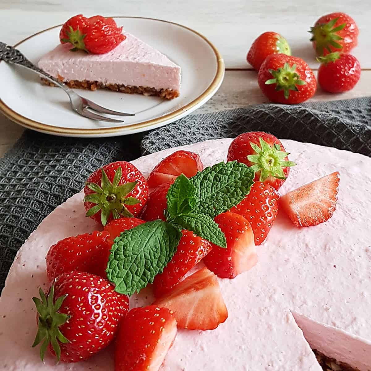 Close-up van een decoratieve verzameling aardbeien met muntblaadjes, als topping van een ontbijttaart.