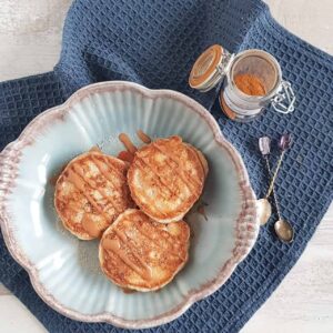 Pannenkoeken met kaneel, kaneelsuiker en een kaneelfrosting in een blauwe kom.