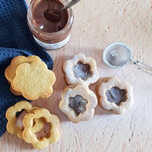 Zandkoekjes met Nutella: de koekjes bestaan uit een bloemvormig deeg met daarop een laagje hazelnootpasta. De koekjes zijn afgedekt met een koekje met een gat in de vorm van een bloem, zodat de vulling goed zichtbaar is.