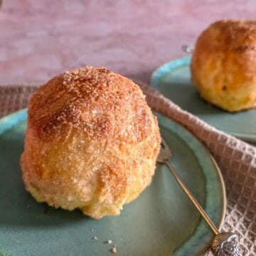 Appelbollen met spijs en rozijnen. Twee appelbollen op een gebaksbordje, met een vorkje ernaast.