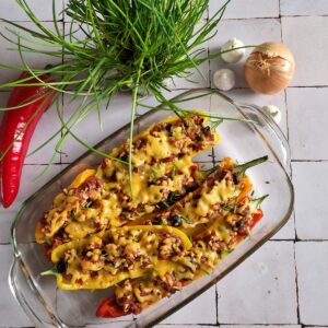 Gevulde paprika met kip en kaas. De puntpaprika's hebben verschillende kleuren (geel en rood).