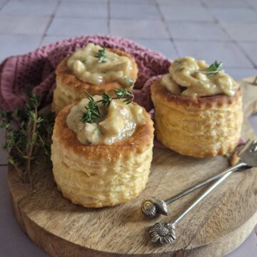 Drie pasteitjes met kippenragout op een serveerplank.