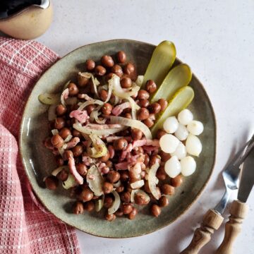 Een bord met kapucijners met spek, stroop en zuur.