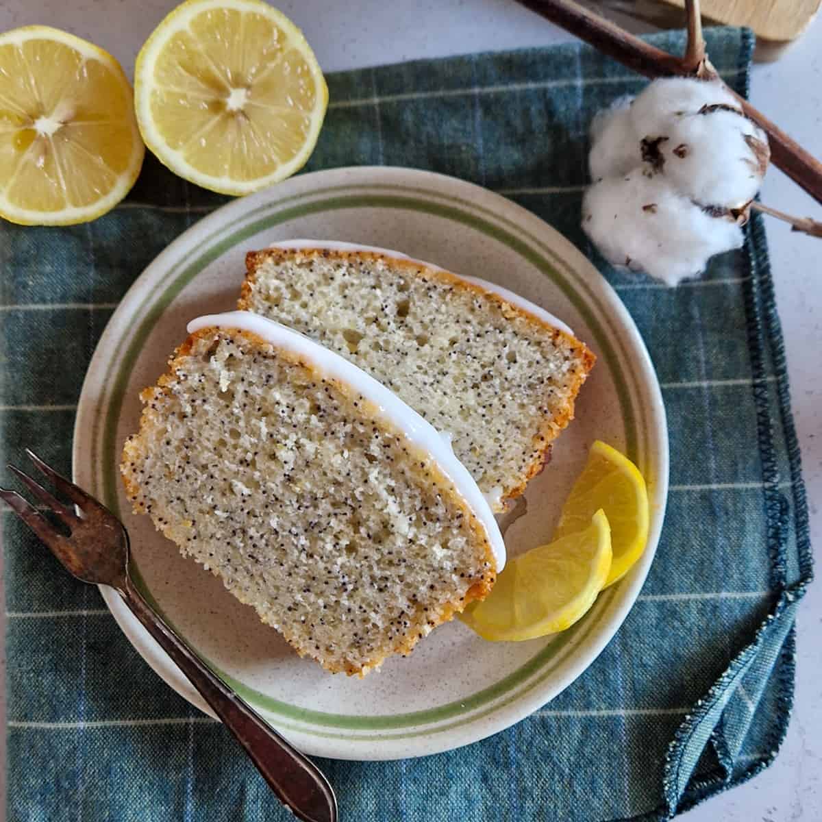 Twee plakken maanzaadcake met citroen op een gebaksbordje.