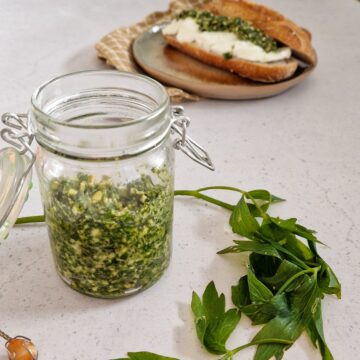 Een potje lavaspesto met lavasbladeren ervoor.