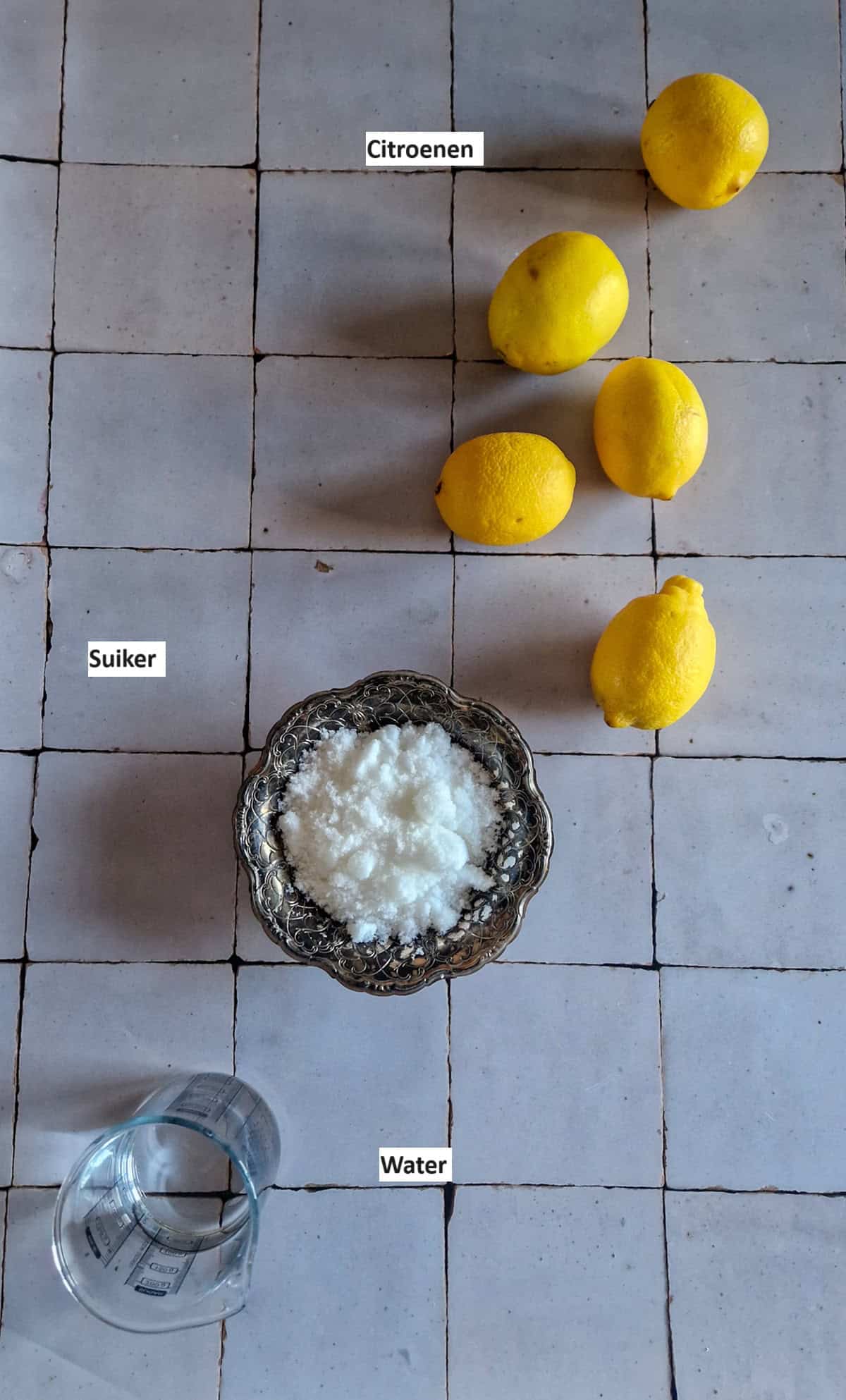 De ingrediënten voor citroensiroop: citroenen, suiker en water.