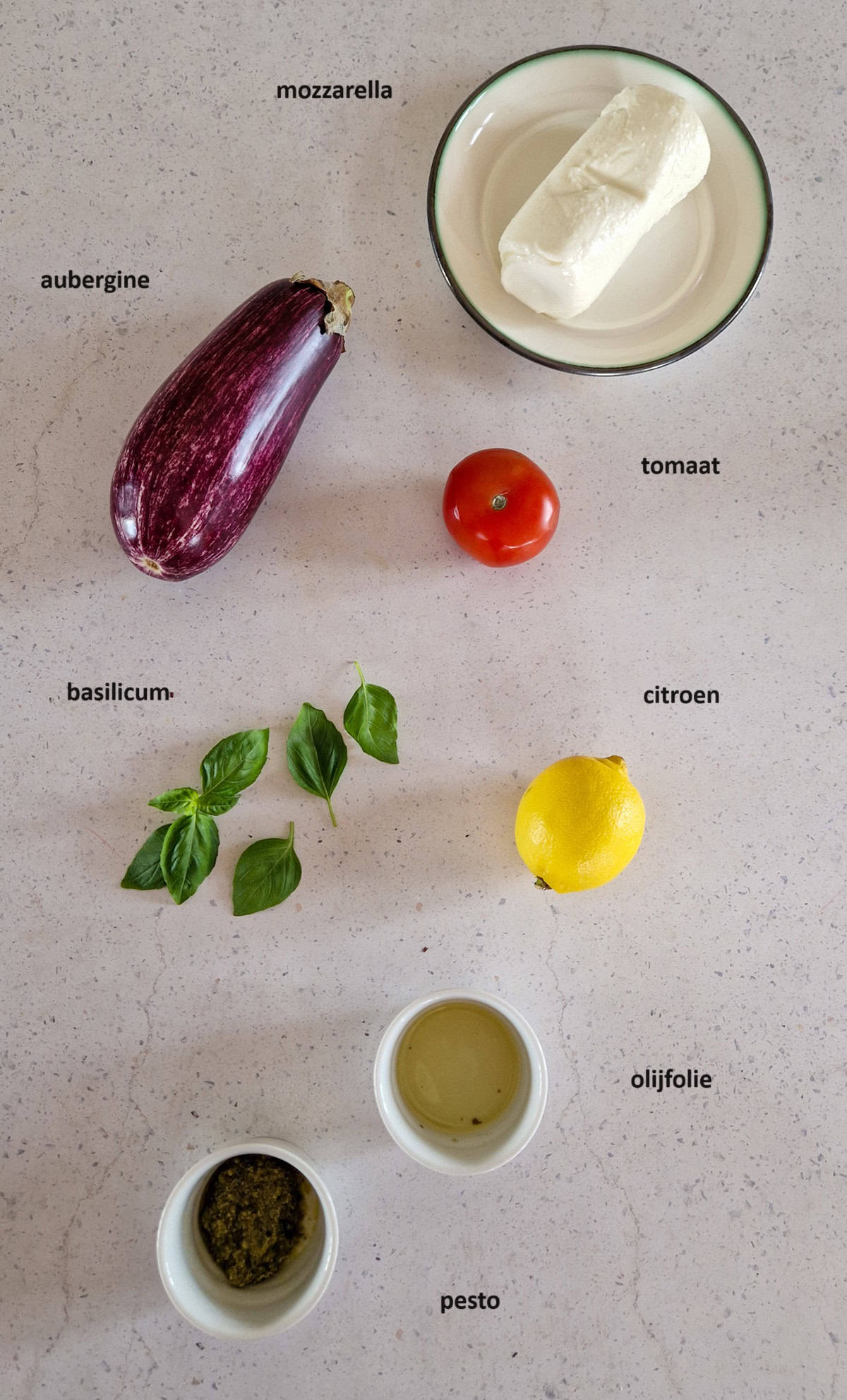 De ingrediënten voor dit recept voor een voorgerecht met aubergine: mozzarella, tomaat, aubergine, citroen, basilicum, pesto.