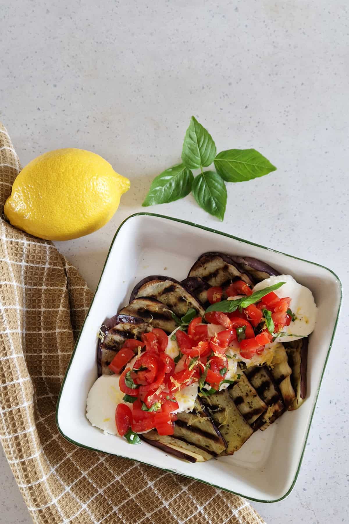 Een vegetarisch voorafje: plakken aubergine die zijn gegrild en geserveerd worden met mozzarella en een tomatensalsa.