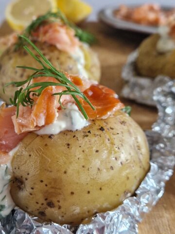 Gepofte aardappel gevuld met warmgerookte zalm en een dille-saus.
