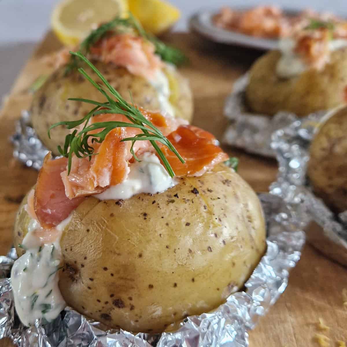 Gepofte aardappel gevuld met warmgerookte zalm en een dille-saus.