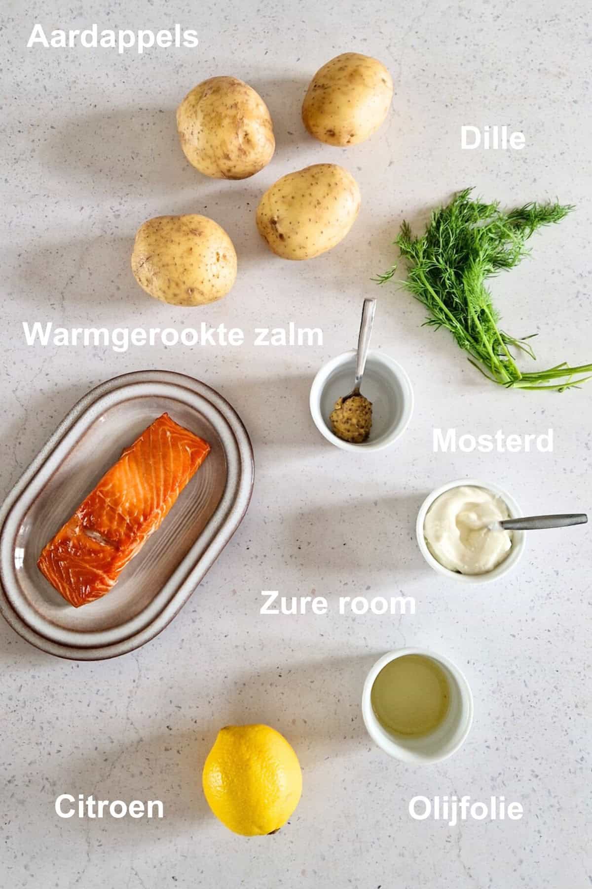 De ingredienten voor gepofte aardappels met warmgerookte zalm. De ingredienten zijn gelabeld.
