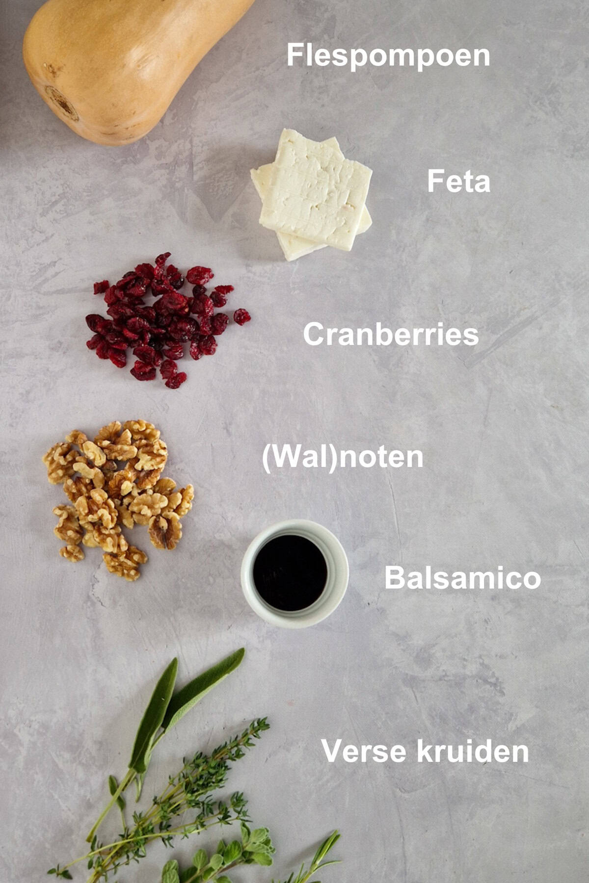 De ingrediënten voor gevulde pompoen uit de oven. Flespompoen, feta, cranberries, walnoten, balsamico en veel verse kruiden.