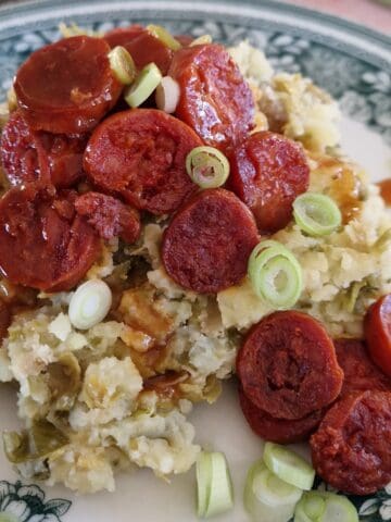 Spruitjes stamppot met chorizo en bosui op een bord met ouderwets motief.