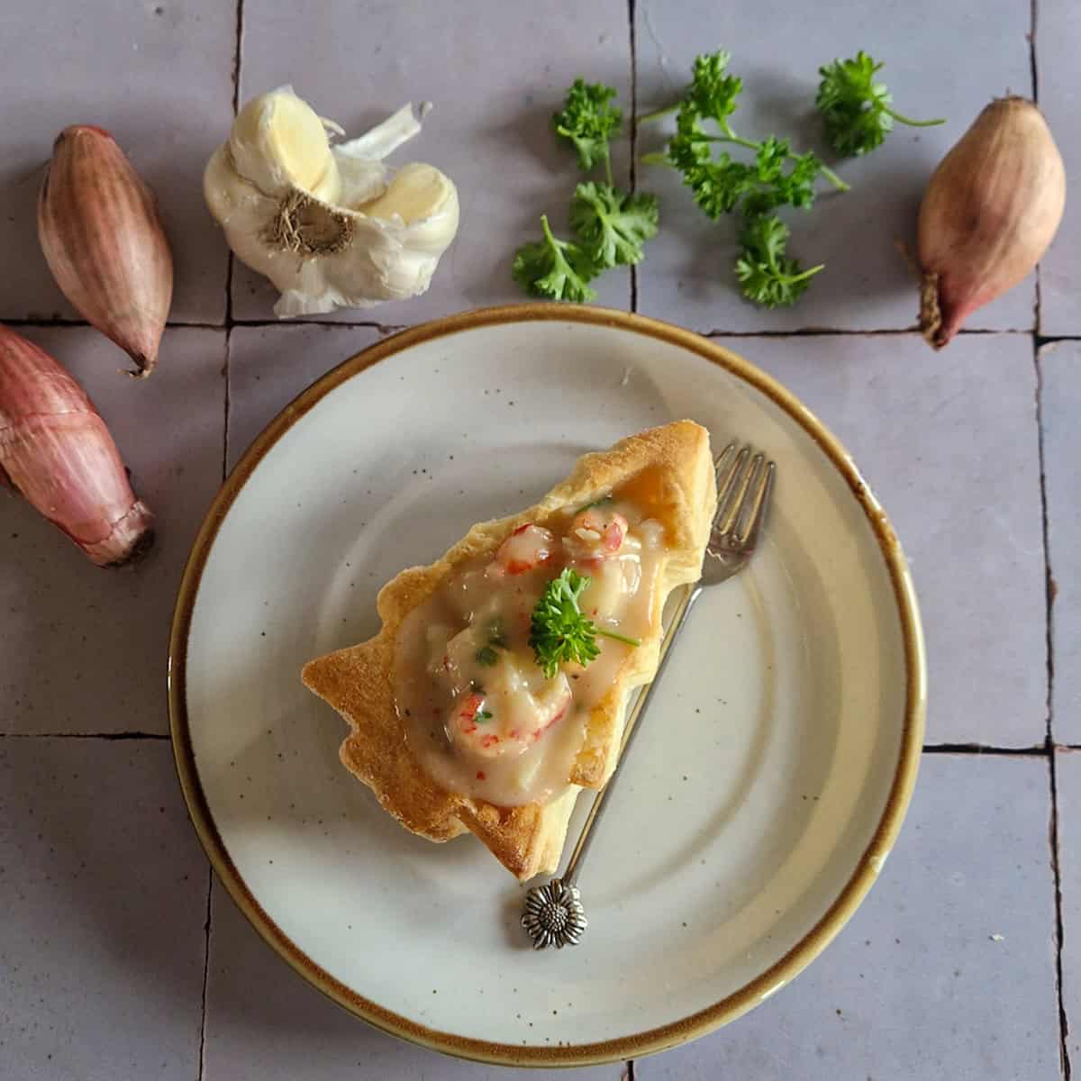 Luxe voorgerecht - pasteitjes met ragout van garnalen en rivierkreeft, op een bordje.