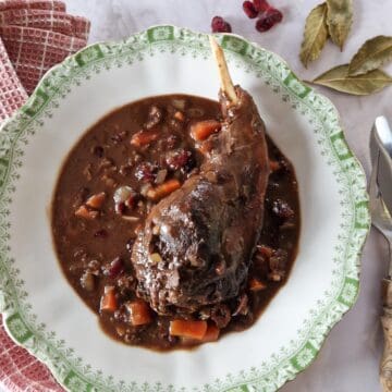 Een hazen stoofpotje in een bord in een rijke, donkere saus met wortel.