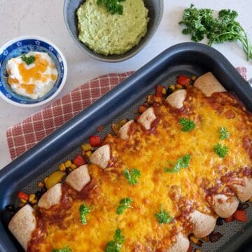 Een ovenschotel met vegetarische enchiladas met een royale laag gegratineerde cheddar.