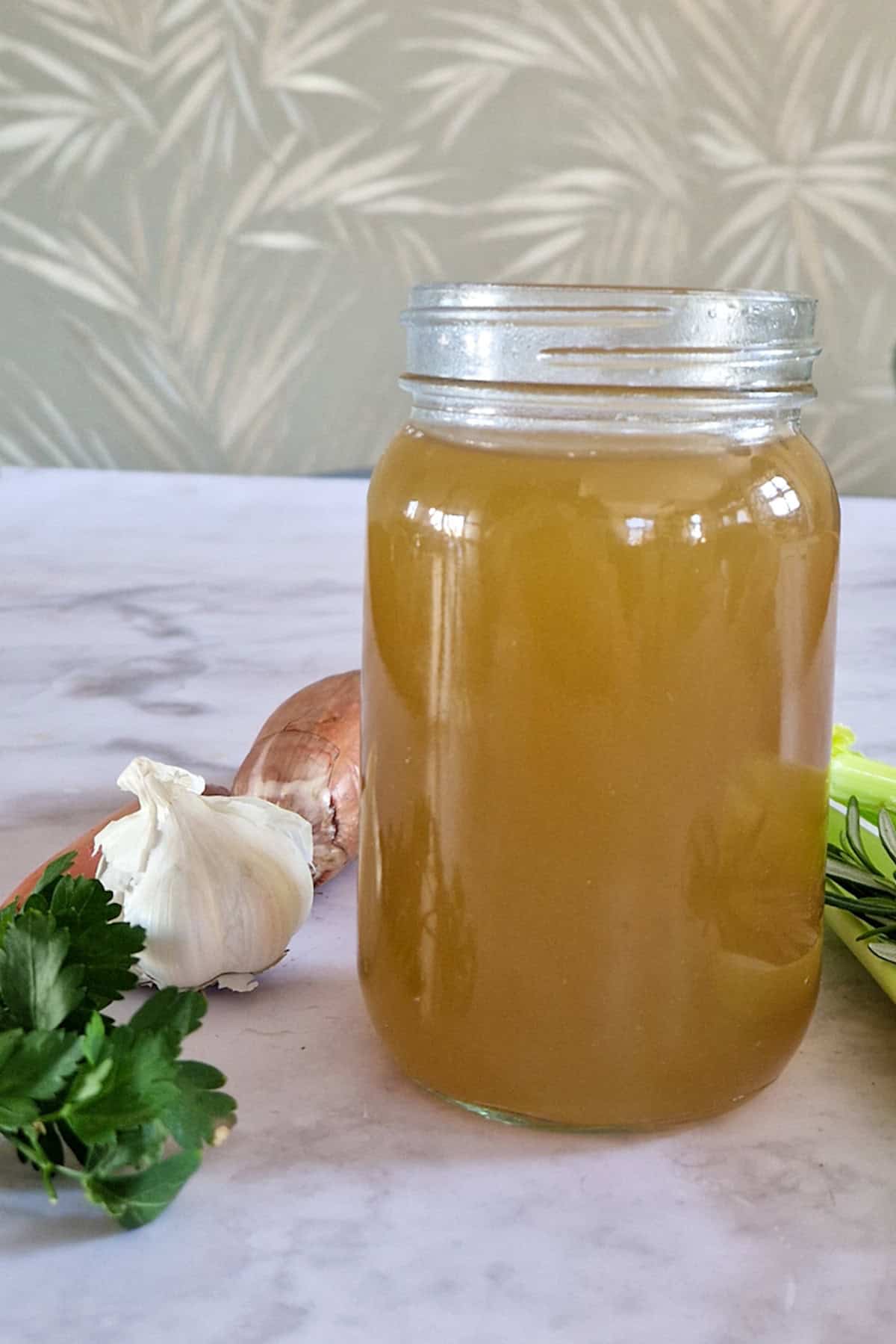 Een glazen pot met groentenbouillon, gemaakt met afsnijdsels van groenten.