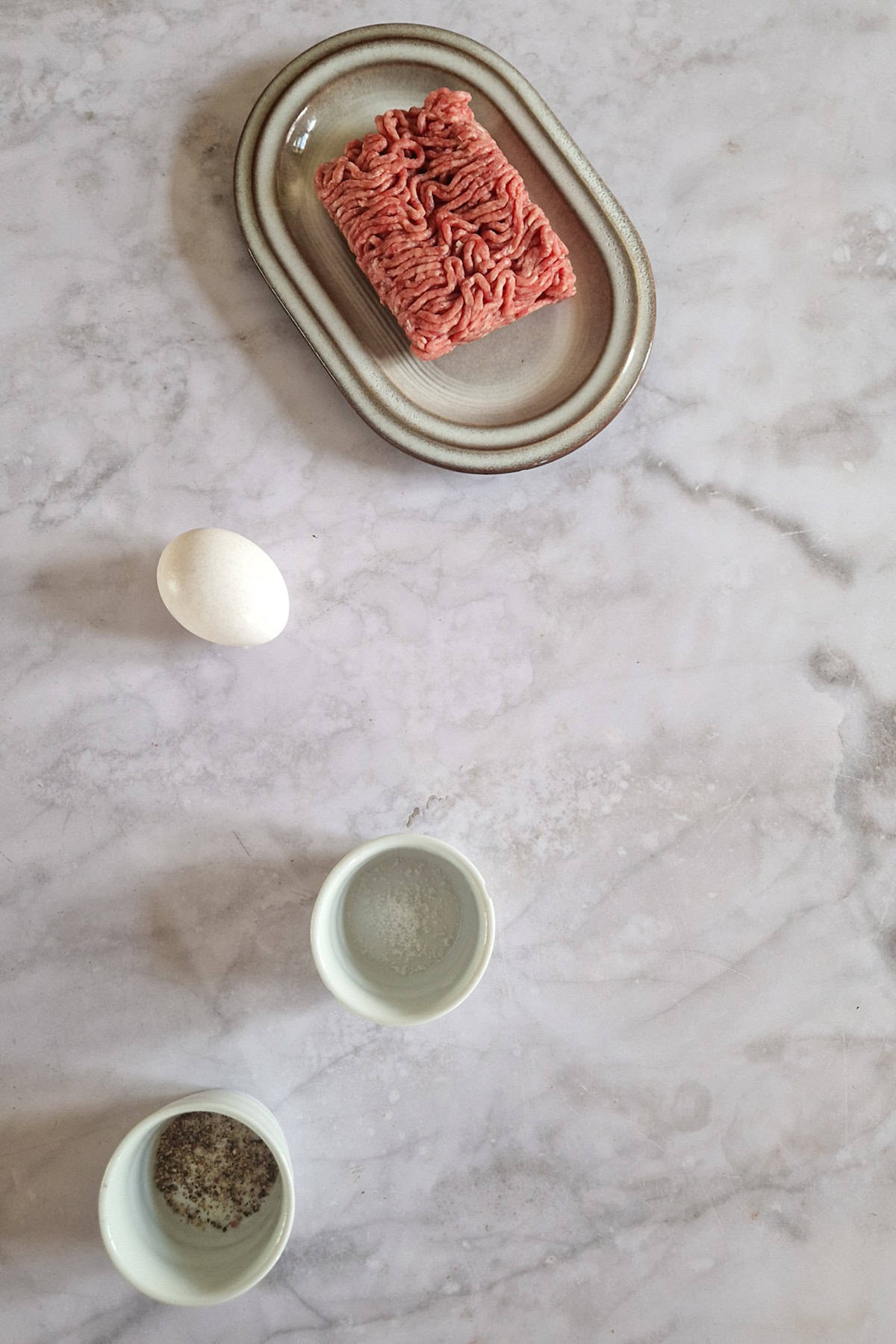 De ingrediënten om zelf soepballetjes te maken: gehakt, ei, peper en zout.