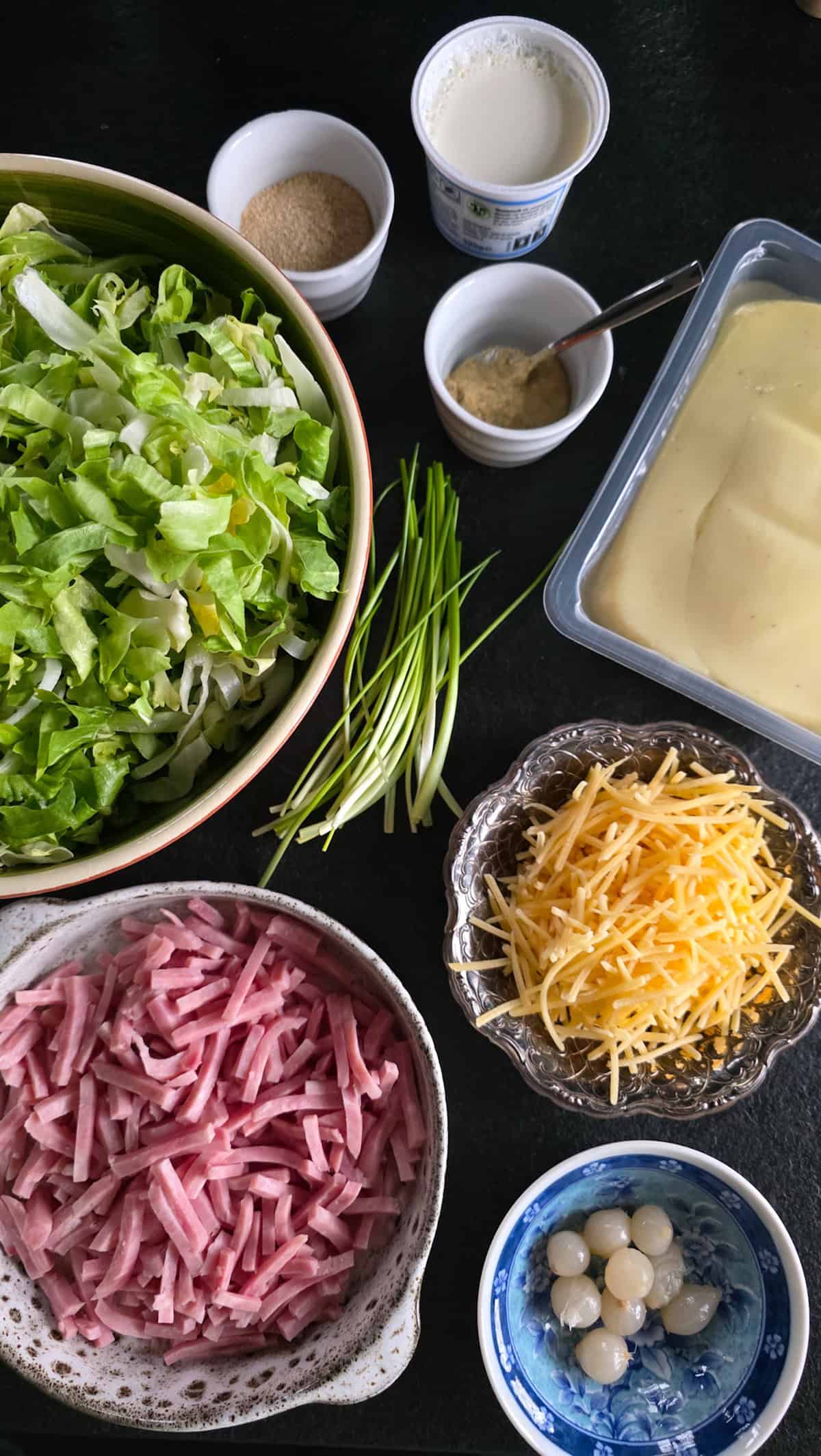 De ingrediënten om andijvieschotel te maken, uitgestald in bakjes.