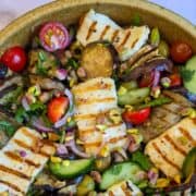 Close-up van een salade met aubergine en gegrilde halloumi.
