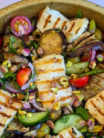 Close-up van een salade met aubergine en gegrilde halloumi.