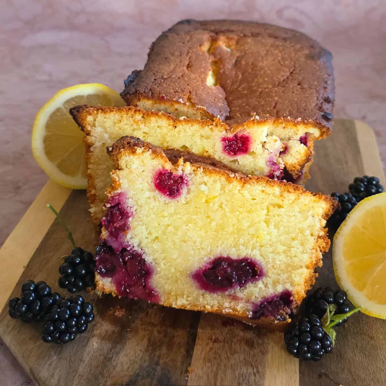 Een bramencake waar twee plakken zijn afgesneden, zodat de binnenkant van de cake goed te zien is.
